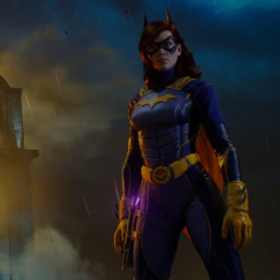 Gotham knights character Batgirl standing at night in a rainstorm and lit by background building lights.